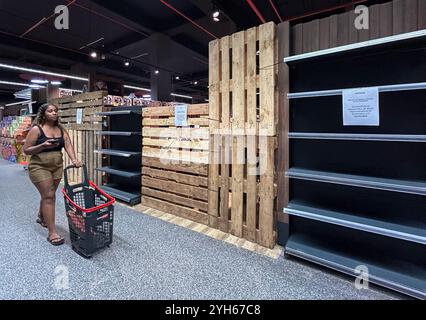 Port Louis. November 2024. Dieses mit einem Mobiltelefon aufgenommene Foto zeigt einen Kunden, der am 9. November 2024 in einem Supermarkt in Moka, Mauritius, an leeren Regalen für alkoholische Getränke vorbeiläuft. Mauritius wird am 10. November die Wahlen zur Nationalversammlung abhalten. Um einen reibungslosen und geordneten Ablauf zu gewährleisten, hat die Polizei ein Verbot des Alkoholverkaufs vom 9. Bis 11. November angekündigt, das den Tag vor den Wahlen, den Wahltag sowie den Tag der Stimmenauszählung abdeckt. Quelle: Li Yahui/Xinhua/Alamy Live News Stockfoto