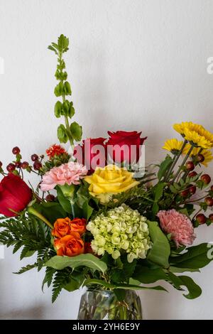 Abstrakte Makroansicht blühender Blumen in einem Blumenarrangement im Innenbereich mit gelben Chrysanthemen und peruanischen Lilien Stockfoto