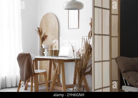 Moderner Arbeitsplatz mit Laptop, Wohnkultur und Klappbildschirm Stockfoto