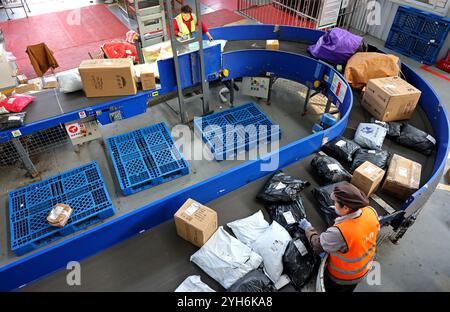 ZAOZHUANG, CHINA - 10. NOVEMBER 2024 - Mitarbeiter arbeiten an einer Montagelinie im Netzwerkbetriebszentrum der Lieferabteilung der China Post Group Co Stockfoto