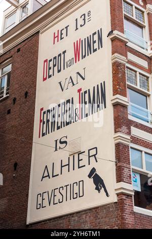 Amsterdam, NL, 10. OKT 2021: Werbung für einen Weinladen mit klassischer Typografie an der Wand eines typisch niederländischen Gebäudes in Amsterdam, der Hauptstadt der Th Stockfoto