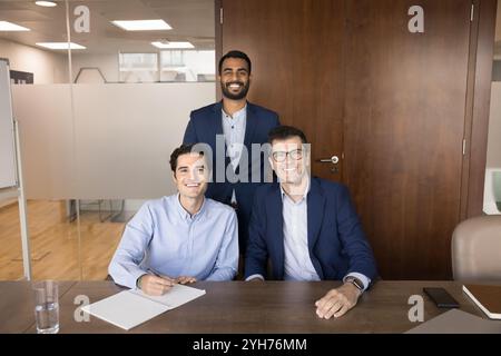 Glückliches erfolgreiches, vielfältiges männliches Business-Team, das sich gemeinsam ausgibt Stockfoto