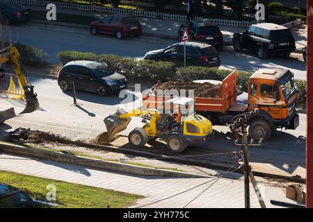 Betonnivellierung für Straßenbaustellen mit Lkw mit Schmutz und Baggermaschine. Straßenbauarbeiten, Straßenbau. Straßensperrungen. Albanien, Vlor Stockfoto