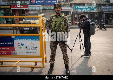 Srinagar, Indien. November 2024. Kaschmiri-Journalist, der Fotos macht, während indischer paramilitärischer Soldat wachsam ist, während die Schießerei am Stadtrand von Srinagar stattfindet. Zwei bis drei Kommandos aus einer Elitegruppe der Indischen Armee wurden bei zwei weiteren Schussgefechten in der unruhigen Himalaya-Region verletzt. Polizeibeamte sagten, dass acht Militante, darunter fünf Ausländer, innerhalb einer Woche getötet wurden, während Regierungskräfte ihre Operationen in der Region intensivieren. Quelle: SOPA Images Limited/Alamy Live News Stockfoto