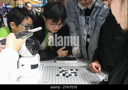 Shanghai. November 2024. Besucher spielen Schach mit einem Roboter während der 7. China International Import Expo (CIIE) im ostchinesischen Shanghai am 9. November 2024. Die 7. CIIE fand hier vom 5. Bis 10. November statt. Viele Aussteller boten verschiedene interaktive Aktivitäten an, um mehr über ihre Produkte und Dienstleistungen zu erfahren. Quelle: Huang Xiaoyong/Xinhua/Alamy Live News Stockfoto