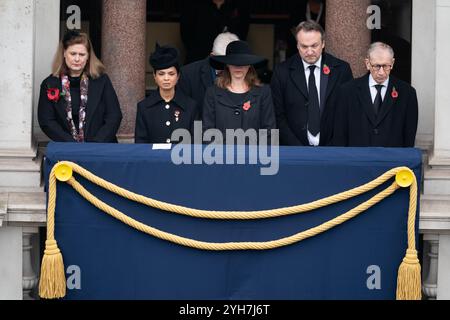 (Vorne links nach rechts) Ehefrau des ehemaligen Premierministers Gordon Brown, Sarah Brown, Ehefrau des ehemaligen Premierministers Rishi Sunak, Akshata Murty, Ehefrau des Premierministers Sir Keir Starmer, Lady Victoria Starmer, Ehemann des ehemaligen Premierministers Liz Truss, Hugh O'Leary und Ehemann der ehemaligen Premierministerin Theresa May, Philip May, Philip May auf einem Balkon im Foreign, Commonwealth and Development Office (FCDO) während der Gedenkfeier in London. Bilddatum: Sonntag, 10. November 2024. Stockfoto