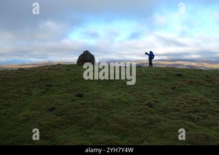 Ein Mann (Wanderer) macht ein Foto des großen Steinhügels auf dem Gipfel des „Elbolton“ (Coral Reef Knoll) in der Nähe von Wharfedale, Yorkshire Dales National Park, Großbritannien. Stockfoto