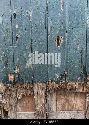 Nahaufnahme einer alten Holztür mit abblätternder Farbstruktur, Hintergrund. Stockfoto