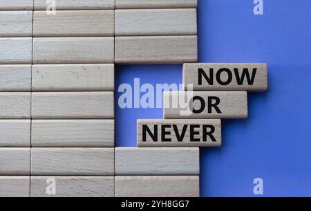 Symbol jetzt oder nie. Begriffe jetzt oder nie auf Holzblöcken. Schöner lila Hintergrund. Business und jetzt oder nie Konzept. Kopierbereich Stockfoto