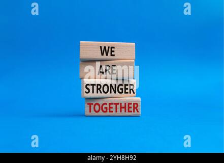 Wir sind gemeinsam stärker Symbol. Holzblöcke mit Worten Wir sind stärker zusammen. Wunderschöner blauer Hintergrund. Wir sind stärker zusammen. Kopieren Stockfoto