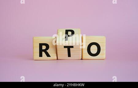 RPO vs. RTO-Symbol. Holzwürfel mit den Worten RTO bis RPO. Schöner rosafarbener Hintergrund. Geschäftskonzept. Kopierbereich Stockfoto