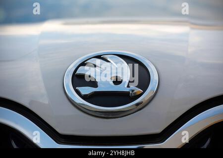 Prag, Tschechische Republik - 29. Oktober 2024: Detail des Skoda-Markenlogos (silberner geflügelter Pfeil auf schwarzem Hintergrund) auf einem weißen Octavia-Auto. Stockfoto