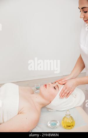 Chiropraktiker-Masseur, Der Frau Im Spa Eine Gesichtsmassage Gibt Stockfoto