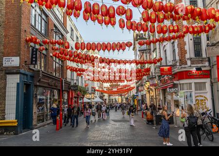 London, Großbritannien – 19. September 2024: Lebhafte Londoner Chinatown-Straßenszene mit roten Laternen, geschäftigen Menschen und kulturellen Geschäften. Stockfoto