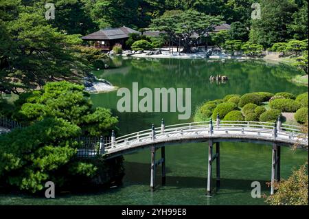 Engetsu Bogenbrücke über den Nanko-Teich mit dem Kikugetsutei-Teehaus im Hintergrund im Ritsurin Koen Japanischen Garten in Takamatsu, Kagawa, Japan. Stockfoto