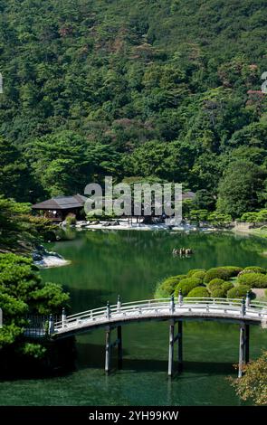 Engetsu Bogenbrücke über den Nanko-Teich mit dem Kikugetsutei-Teehaus im Hintergrund im Ritsurin Koen Japanischen Garten in Takamatsu, Kagawa, Japan. Stockfoto