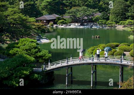 Engetsu Bogenbrücke über den Nanko-Teich mit dem Kikugetsutei-Teehaus im Hintergrund im Ritsurin Koen Japanischen Garten in Takamatsu, Kagawa, Japan. Stockfoto