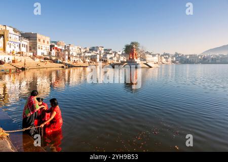 Pushkar See. Hinduistische Pilger, die im heiligen Pushkar-See auf Ghats baden. Unzählige Menschen in farbenfroher Kleidung versammeln sich, um ein Bad im Heiligen See zu nehmen und p Stockfoto