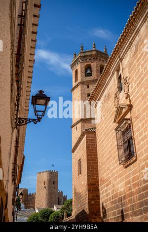 Straße in der Altstadt von Baños de la Encina, Jaen, Andalusien, Spanien, mit der Kirche San Mateo und Burgalimar Burg im Hintergrund Stockfoto