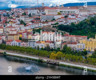 Aus der Vogelperspektive auf die Altstadt von Coimbra auf dem Hügel. Panoramablick auf die Stadt der Drohne und den Fluss Mondego, Portugal Stockfoto