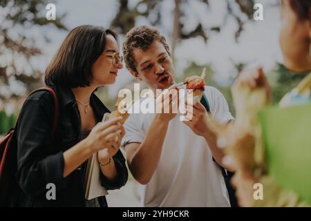 Multikulturelle Schüler genießen zwischen den Klassen Eis in einem Park Stockfoto
