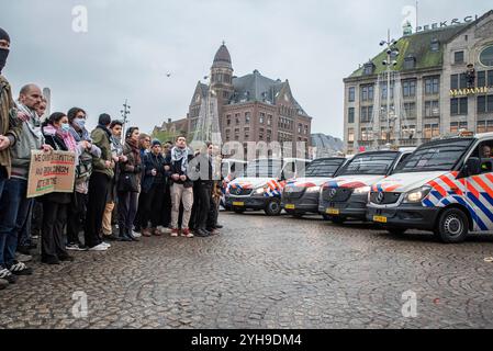 Amsterdam, Nordholland, Niederlande. November 2024. Eine große Gruppe von Demonstranten steht umgeben von niederländischen Polizeifahrzeugen. Am 10. November 2024 hielten Demonstranten in den Niederlanden einen unerlaubten Protest auf dem Dam-Platz in Amsterdam ab. Dies geschah als Reaktion auf die Bezeichnung eines Protests vom 7. November, der gewalttätig als antisemitisch wurde, und das anschließende vorübergehende Verbot von Protesten in Amsterdam. (Kreditbild: © James Petermeier/ZUMA Press Wire) NUR REDAKTIONELLE VERWENDUNG! Nicht für kommerzielle ZWECKE! Quelle: ZUMA Press, Inc./Alamy Live News Stockfoto