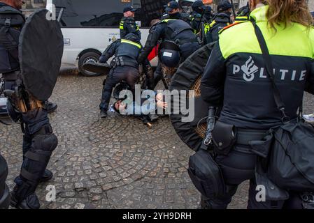 Amsterdam, Nordholland, Niederlande. November 2024. Nachdem er von der niederländischen Polizei angegriffen wurde, greift ein Demonstrant schmerzhaft sein Bein. Am 10. November 2024 hielten Demonstranten in den Niederlanden einen unerlaubten Protest auf dem Dam-Platz in Amsterdam ab. Dies geschah als Reaktion auf die Bezeichnung eines Protests vom 7. November, der gewalttätig als antisemitisch wurde, und das anschließende vorübergehende Verbot von Protesten in Amsterdam. (Kreditbild: © James Petermeier/ZUMA Press Wire) NUR REDAKTIONELLE VERWENDUNG! Nicht für kommerzielle ZWECKE! Quelle: ZUMA Press, Inc./Alamy Live News Stockfoto