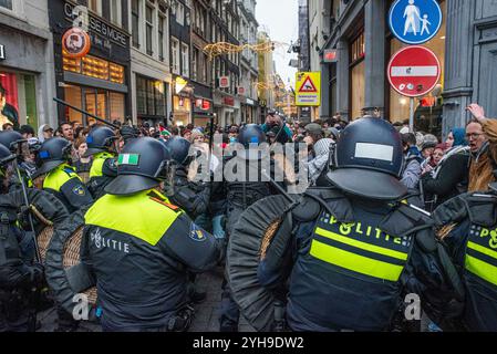 Amsterdam, Nordholland, Niederlande. November 2024. Die niederländische Polizei bringt mit ihren Schlagstöcken eine Gruppe Demonstranten in eine Seitenstraße, bevor sie verhaftet werden. Am 10. November 2024 hielten Demonstranten in den Niederlanden einen unerlaubten Protest auf dem Dam-Platz in Amsterdam ab. Dies geschah als Reaktion auf die Bezeichnung eines Protests vom 7. November, der gewalttätig als antisemitisch wurde, und das anschließende vorübergehende Verbot von Protesten in Amsterdam. (Kreditbild: © James Petermeier/ZUMA Press Wire) NUR REDAKTIONELLE VERWENDUNG! Nicht für kommerzielle ZWECKE! Quelle: ZUMA Press, Inc./Alamy Live News Stockfoto