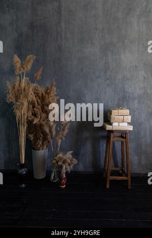 Getrocknete Blumen Pflanzen In Vasen Und Holzstuhl Im Grauen Raum Stockfoto