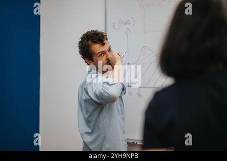 Der Lehrer erklärt während des Unterrichts komplexe Diagramme auf dem Whiteboard Stockfoto