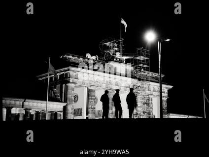 © John Angerson. November 1989: Ostberliner strömen nach West-Berlin, passieren das berühmte Brandenburger Tor, werden mit Anfeuerungen, Umarmungen und dem historischen Begrüßungsgeld begrüßt. Fröhliche Menschenmassen feiern die neu entdeckte Freiheit, wenn die Berliner Mauer fällt und das Ende der Jahrzehnte der Teilung markiert.“ Stockfoto