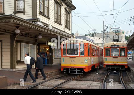 Zwei Straßenbahnen (Shiden) warten am Bahnsteig Dogo Onsen in Matsuyama, Ehime, Japan Stockfoto