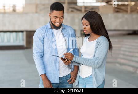 Weibliche Interviewer, Wähler Umfrage im Freien nach Wahl Stockfoto