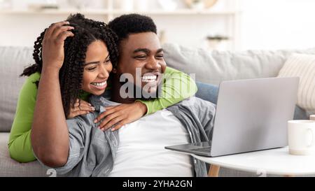 Caring Black Frau Unterstützung Freund Während Er Arbeiten Auf Laptop Zu Hause Stockfoto