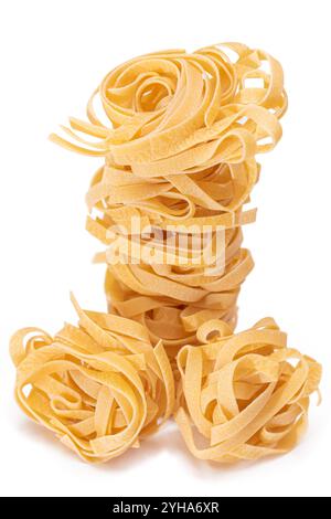 Classic Italian Raw Egg Fettuccine - isoliert auf weißem Hintergrund. Getrocknete, Ungekochte Nudeln. Italienische Kultur und Küche. Rohe Goldene Makkaroni-Muster - Isolierung Stockfoto