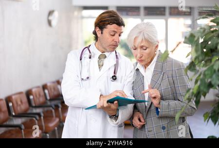 Aufmerksamer Arzt verschreibt Tests an Patienten der Klinik, um den Gesundheitszustand zu überprüfen Stockfoto