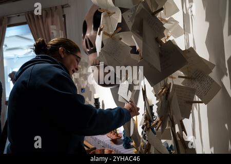 Besucher schreiben Nachrichten für Verstorbene an einem Altar der Gemeinde Dia de los Muertos im Fundación Casa de México en España in Madrid, Spanien. Stockfoto