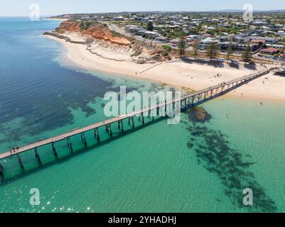 Aus der Vogelperspektive auf einen langen schmalen Steg, der von einem Strand vor einer Küstenstadt in Port Noarlunga in South Australia kommt Stockfoto