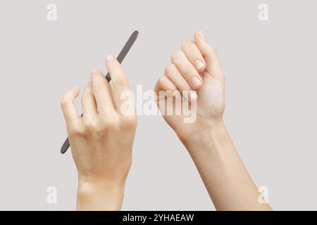 Frau feilt beschädigte Nägel. Fingernägel mit Onycholyse nach Entfernung von gelpolitur Stockfoto