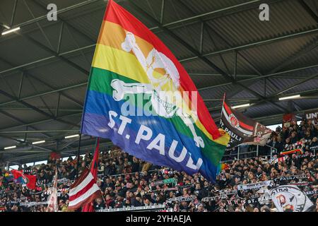 Hamburg, Deutschland. November 2024. 1. Bundesliga - FC St. Pauli - FC Bayern München am 09.11.2024 im Millerntor-Stadion Hamburg die St Pauli Fans schwenken auf der Gegengerade eine St Pauli Schwenkfahne mit Totenkopf in Regenbogen Farben Foto: Osnapix DFL-Vorschriften verbieten jede Verwendung von Fotografien als Bildsequenzen und/oder Quasi-Video Credit: dpa/Alamy Live News Stockfoto