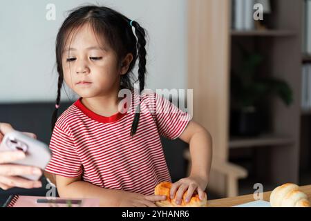 Neugieriges Kind, das zu Hause Lernaktivitäten mit Büchern und Lernspielzeug in einer gemütlichen Umgebung absolviert Stockfoto