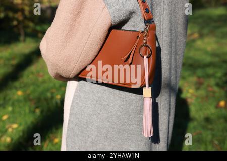 Frau mit rosa Leder Schlüsselanhänger an ihrer Tasche draußen, Nahaufnahme Stockfoto