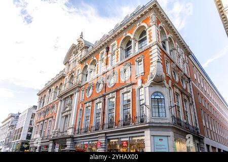 London, Großbritannien - 19. September 2024: Elegante architektonische Fassade eines historischen Red Brick Building im Zentrum von London mit kunstvollen Details und gewölbten Gewölben Stockfoto