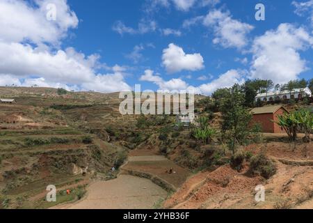 Weitläufige ländliche Landschaft mit grünen und braunen Feldern unter bewölktem Himmel. Ländliche Landschaft, Isalo Nationalpark, Madagaskar. Stockfoto