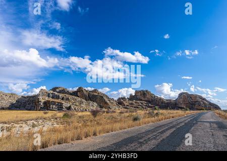 Atemberaubende Felsformationen unter einem hellblauen Himmel. Das zerklüftete Gelände und die farbenfrohen Felsen sind Zeugnis der geologischen Formationen des Juras. Isalo Natio Stockfoto