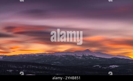 Unglaubliche Sonnenuntergänge in der Wintersaison vom Norden Kanadas mit leuchtend rosa Wolken, Bergen und Schnee in der Dämmerung. Stockfoto