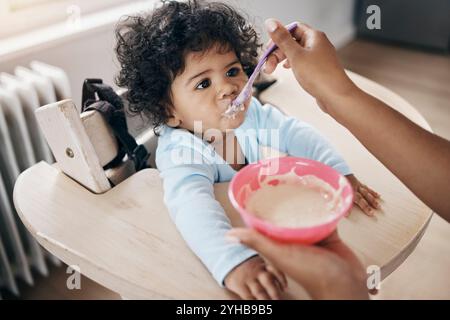 Säugling, Elternhände und Brei zu Hause, Frühstück und Ernährung für gesundes Wachstum. Küche, Tochter und Unterstützung in der kindlichen Entwicklung für Wellness Stockfoto