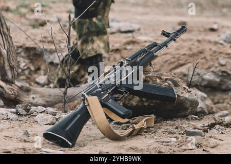 Ein Kalaschnikow-Sturmgewehr liegt auf dem Boden. Der Begriff des Krieges Stockfoto