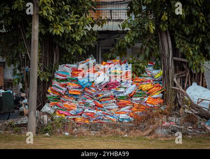 Ein großer Haufen bunter Plastiktüten, die in einem Außenbereich gestapelt sind und die Probleme von städtischem Abfall und Umweltverschmutzung hervorheben Stockfoto