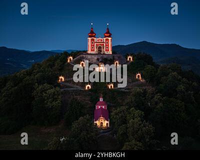 Banska Stiavnica, Slowakei - aus der Vogelperspektive auf den wunderschönen beleuchteten barocken Kalvarienkalvaria in der Slowakei bei Dämmerung an einem Sommernachmittag mit klarem blauem Himmel Stockfoto